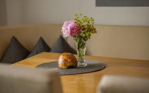 a vase of flowers sitting on a table with a vase of flowers at Ferienwohnung Schnappenblick in Grassau