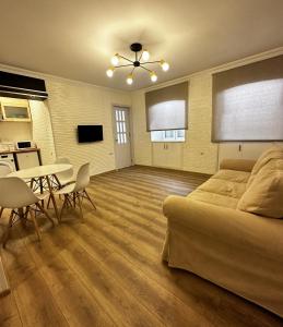 uma sala de estar com uma cama, uma mesa e cadeiras em Cozy apartment em Tbilisi