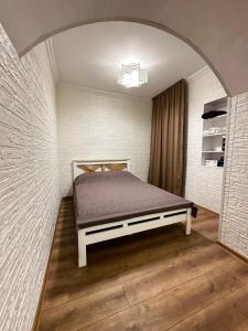um quarto com uma cama num quarto em Cozy apartment em Tbilisi