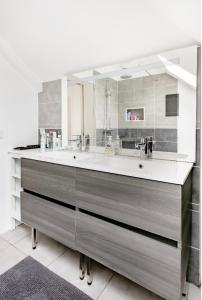 a bathroom with a large sink and a mirror at Chambre a la Ferte in La Ferté-sous-Jouarre