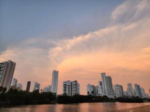 a city skyline with tall buildings and a body of water at A walk to the beach in Cartagena de Indias