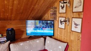 uma televisão de ecrã plano numa parede acima de um sofá em Le Chalet n 0082 em La Thuile