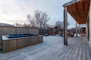 a deck with a hot tub and a gazebo at Húsafell holiday homes in Húsafell