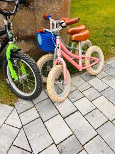 two bikes parked next to each other on a sidewalk at I - caly apartament z dużym tarasem Warmia Kids&chill raj dla dzieci in Gietrzwałd