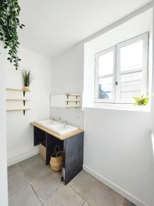 a bathroom with a sink and a window at COAST - Utopy Hostel in Biarritz