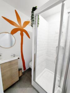 a bathroom with a shower with a palm tree on the wall at COAST - Utopy Hostel in Biarritz