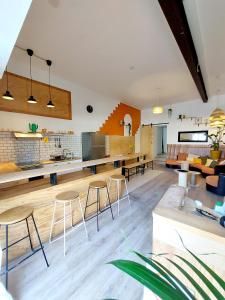 een grote woonkamer met stoelen en een keuken bij COAST - Utopy Hostel in Biarritz