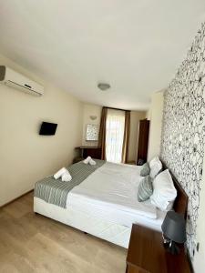 Un dormitorio con una gran cama blanca y una ventana en Sea View en Primorsko