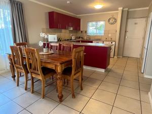 a kitchen with a wooden table and chairs at Beautiful 3 Bedroom Ground floor apartment - 66 Santini Village in Plettenberg Bay