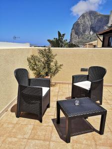 dwa krzesła i stół na patio w obiekcie APPARTAMENTO A SAN VITO LO CAPO STANZA CON BAGNO w mieście San Vito lo Capo