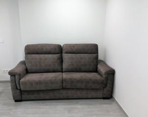 eine braune Couch, die an einer weißen Wand sitzt in der Unterkunft Kiriki Ideal para 2 personas, centro pueblo by Egona in Zarautz