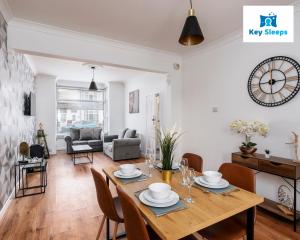 a dining room and living room with a table and chairs at Stunning Three Bedroom House At Keysleeps Short Lets Cleethorpes With Free Parking & Beach Location in Cleethorpes