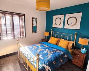 1 dormitorio con cama y pared azul en No.2 Boutique Art Townhouse , en Lincolnshire