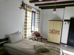 1 dormitorio con 1 cama grande y 1 silla en The Legends , Art & Forest en Gabrovo