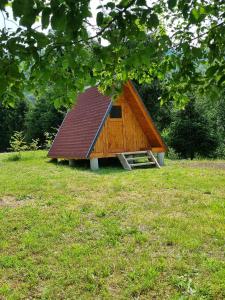 a small house with a roof on a field at GLAMPING HOUSE ˇVITAˇ in Tolmin