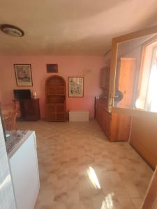 una cucina con pareti rosa e pavimento piastrellato di Isola del Giglio Casa Cecilia GIGLIO Porto loc Monticello a Giglio Castello