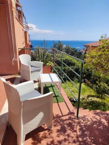 2 sillas y una mesa en un balcón con vistas al océano en Isola del Giglio Casa Cecilia GIGLIO Porto loc Monticello en Isola del Giglio