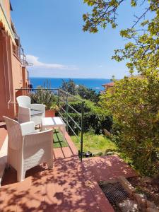 een balkon met stoelen en uitzicht op de oceaan bij Isola del Giglio Casa Cecilia GIGLIO Porto loc Monticello in Isola del Giglio
