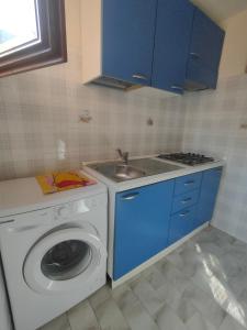 eine Küche mit einer Waschmaschine und einem Waschbecken in der Unterkunft Isola del Giglio Casa Cecilia GIGLIO Porto loc Monticello in Isola del Giglio