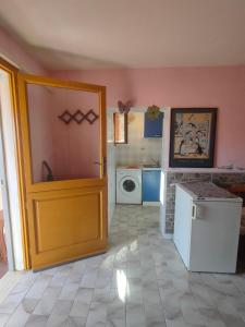 uma cozinha com uma porta e uma máquina de lavar roupa em Isola del Giglio Casa Cecilia GIGLIO Porto loc Monticello em Giglio Castello