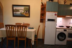 a kitchen with a table and a white refrigerator at Anthias Beach Home in Archangelos