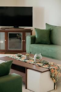 sala de estar con mesa de centro y TV en AKANTHOS Rental House en Kórinthos