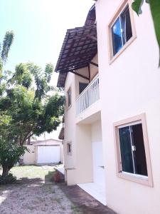 a white building with a tree next to it at Duplex Arretadinho in Aquiraz +10 photos