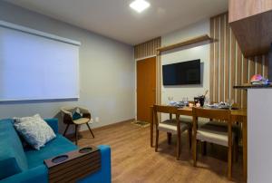 a living room with a blue couch and a table at Nosso apto em Pinhal in Espirito Santo Do Pinhal