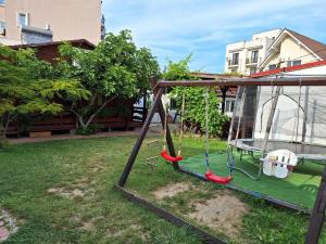 a swing set in a yard at Casa Cris Will in Mamaia Nord