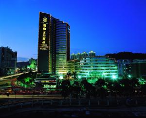 a large building at night with traffic in front of it at Yindo Jasper Hotel Zhuhai in Zhuhai