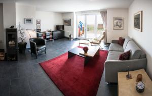 ein Wohnzimmer mit einem Sofa und einem roten Teppich in der Unterkunft Deichhaus Brisinga in Breege