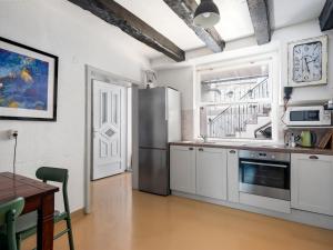 La cuisine est équipée de placards blancs et d'un réfrigérateur en acier inoxydable. dans l'établissement Hanna Cozy Old Stone House, à Murter