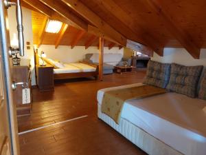 a bedroom with two beds and a wooden floor at Nostos Apartments in Nea Mesangala