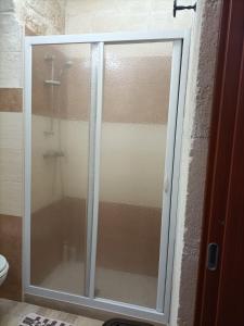 un bagno con servizi igienici e porta doccia in vetro. di Florooms Dimora in stile Rustico-Moderno a Corato