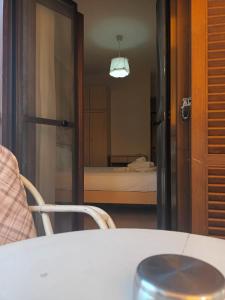 Pokój ze stołem i sypialnią z łóżkiem w obiekcie Hotel Viky w mieście Sarti