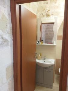 ein Bad mit einem Waschbecken und einem Spiegel in der Unterkunft Florooms Dimora in stile Rustico-Moderno in Corato