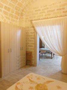 1 dormitorio con cama y cortina blanca en Florooms Dimora in stile Rustico-Moderno, en Corato