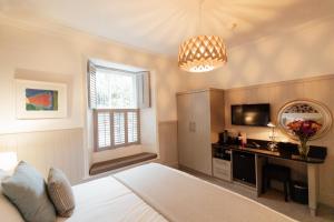 a bedroom with a bed and a tv and a window at 27 The Terrace in St Ives