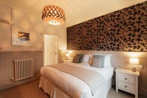 a bedroom with a large bed with a floral accent wall at 27 The Terrace in St Ives