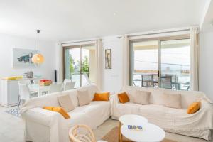 una sala de estar con 2 sofás blancos y una mesa. en Adosado Bellavista B By homevillas360, en Alcanada