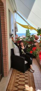 een vrouw op een stoel op een balkon bij A casa di Ilde in Silvi Paese