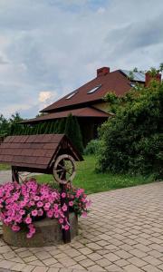 サンドミエシュにあるAgroturystyka Agnieszki Murszewskiejの建物前のピンクの花のベンチ