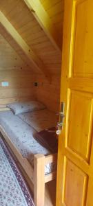Rúm í herbergi á Konaci Očeva Zemlja Vikendica i Bungalovi