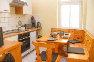 a kitchen with a wooden table with chairs and a stove at Bischofswerda Ferienwohnung Familienfreundlich Seniorengerecht in Bischofswerda