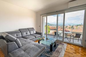 un soggiorno con divano e una grande finestra di Apartment Aida No1 City view - Free Parking - a Sarajevo