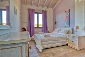 a bedroom with a large bed and purple curtains at La Poggiata in Monterotondo