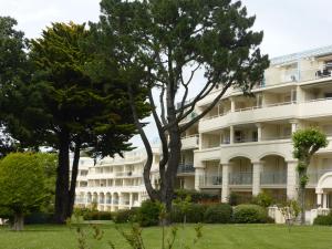 拉波勒的住宿－Studio à 300m de la plage, parc, piscine, terrasse，前面有树木的白色大建筑