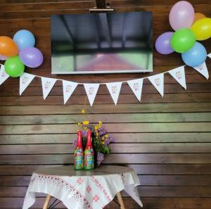 a table with a tv and a bunch of balloons at Relax and Smile Rameț in Biceşti