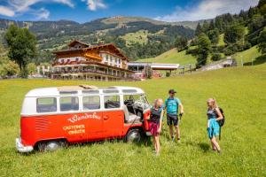 grupa ludzi stojących obok vana na polu w obiekcie Aktivhotel Gasteiner Einkehr w mieście Dorfgastein