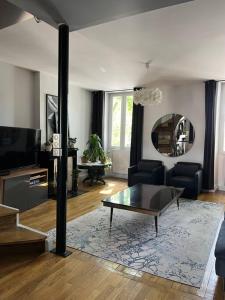 a living room with a couch and a coffee table at Duplex de charme en centre ville avec terrasse in Brive-la-Gaillarde